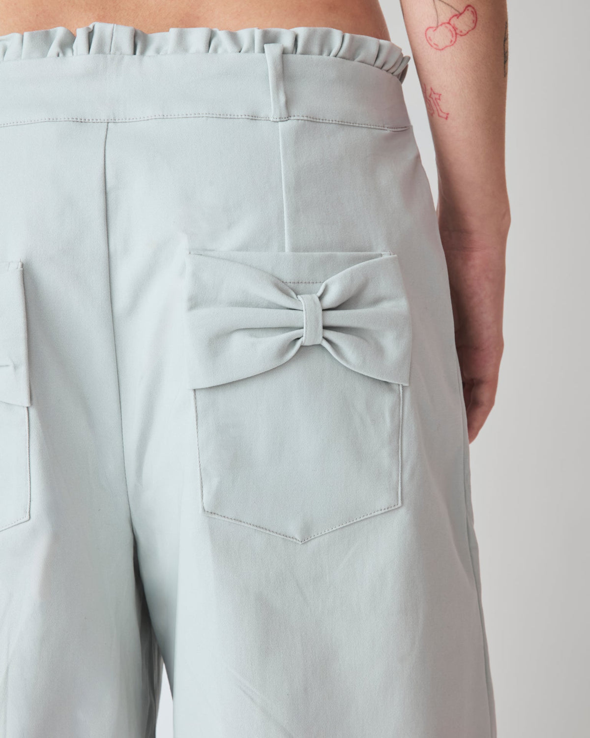 Jorts Leoni Cinza Céu — detalhe do bolso com laço