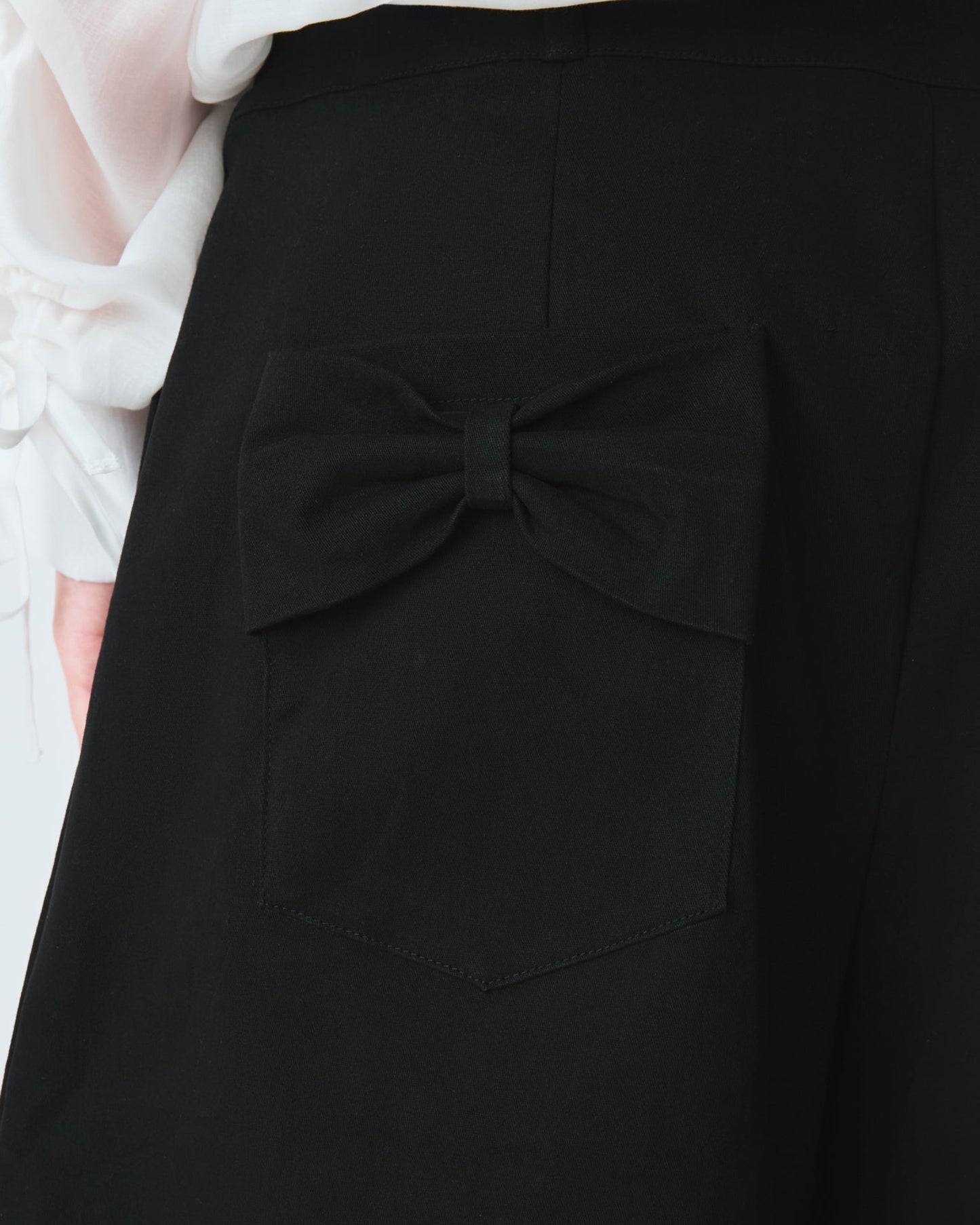 Jorts Leoni Preto — detalhe do bolso com laço